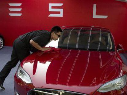 Un empleado de Tesla limpia un Modelo S en una tienda de la compa&ntilde;&iacute;a en Pek&iacute;n (China).