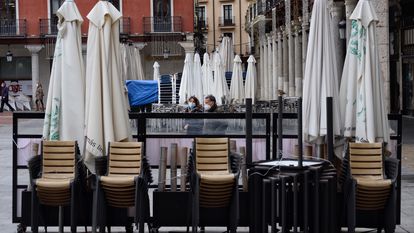 Varias sillas y mesas de la terraza de un bar recogidas ante el cierre por la pandemia, en Castilla y León.