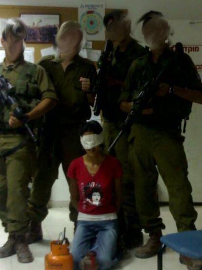 Un grupo de soldados posa con un ciudadano palestino tras ser detenido.