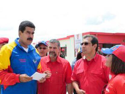 Fotografía cedida por el Palacio de Miraflores donde aparece el presidente Nicolás Maduro con su ministro de Vivienda, Ricardo Molina (2-i), y el gobernador de Barinas, Adan Chávez (2-d), este jueves 16 de mayo de 2013, durante el acto de entrega de 75 viviendas en Barinas (Venezuela).