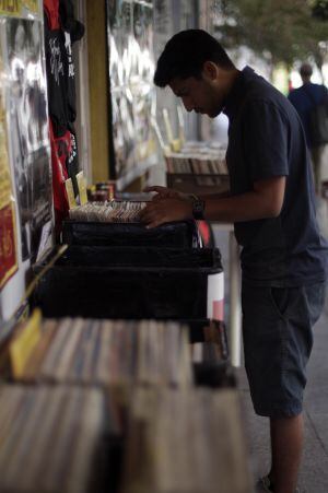 Un joven busca un disco de vinilo en la tienda de La Gramola.