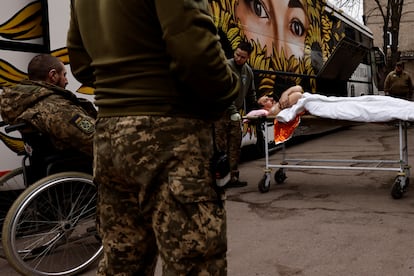 Un soldado ucranio herido es trasladado en camilla a un autobús cerca del frente de Bajmut, en el este de Ucrania.