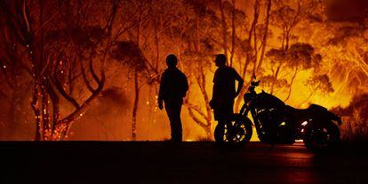 Dois residentes observam os lumes em Lake Tabourie, Austrália.