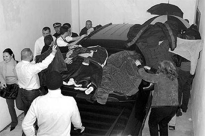 Policías locales de Marbella cubren el coche que sacó anoche de los juzgados a los compañeros acusados.