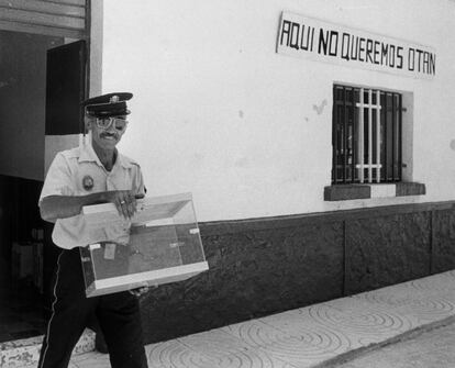 Un policía municipal se dirige el 22 de junio de 1986 al colegio electoral con una urna en Marinaleda (Sevilla), en cuya fachada se puede leer: "Aquí no queremos OTAN". Las segundas elecciones autonómicas andaluzas coincidieron con las generales, que por primera vez se celebraban en domingo y también las primeras en las que se aplicó el modelo D'Hondt.  El PSOE repitió la mayoría absoluta, pero perdió seis escaños, quedándose en 60. José Rodríguez de la Borbolla, ganador de las elecciones, se había convertido dos años antes en el presidente de la Junta de Andalucía tras la dimisión de Rafael Escuredo. Las claves de la crisis: el retraso en transferencias clave para la reforma agraria propuesta por Escuredo, las diferencias con el Gobierno sobre la Expo 92, y las sospechas sobre la financiación de su lujosa vivienda cerca de Sevilla,