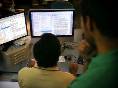 Un trabajador lee el correo electr&oacute;nico en un ordenador de la oficina.