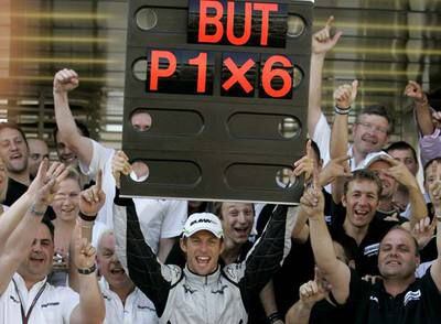Button celebra su sexto triunfo de la temporada con los mecánicos de Brawn.