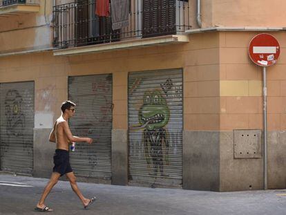 Un turista descamisado pasea por el centro hist&oacute;rico de Palma.