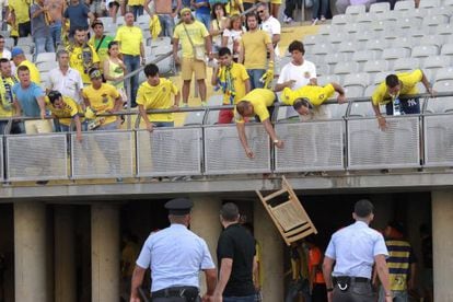 Aficionados del Las Palmas lanzan una silla desde la grada.