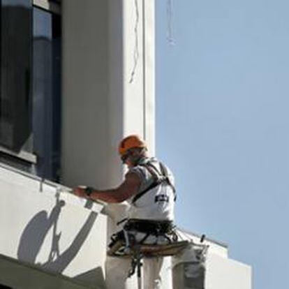 Un pintor trabaja sobre una vivienda de un edificio