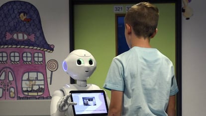 Un ni&ntilde;o habla con el robot Pepper.