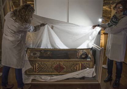 Dos conservadoras desembalan la caja mortuoria de Isabel de Aragón en el monasterio de Sijena tras su llegada desde el Museo de Lleida.