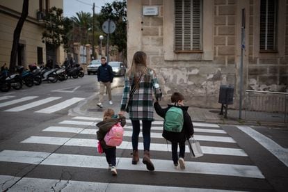 Una mujer acompaña a dos niños al colegio en Cataluña.