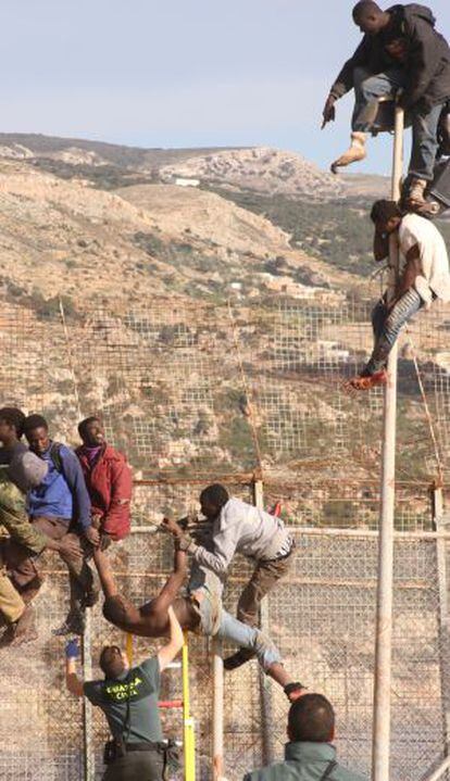 Algunos de los inmigrantes encaramados a la valla de Melilla.