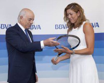 La tenista Garbiñe Muguruza entrega una de sus raquetas al presidente de BBVA, Francisco González