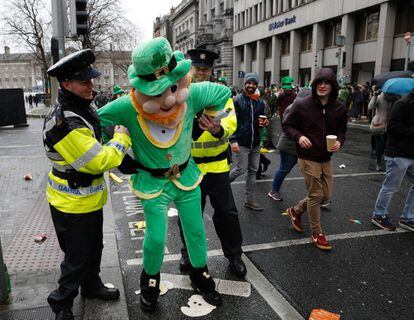 Policías fingen arrestar a un hombre disfrazado de leprechaun durante el desfile de San Patricio en Dublín, Irlanda.