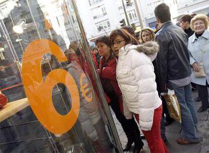 Varias personas hacen cola en una tienda de la Gran Vía.