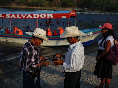 Turistas pagan un viaje en bote en el lago Ilopango, en Santiago Texacuangos (El Salvador), el 17 de marzo.