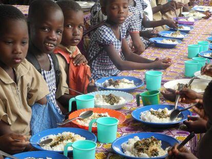Un grupo de escolares come arroz en el centro educativo de N’Zikro, en Costa de Marfil.