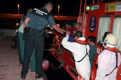 Agentes de la Guardia Civil ayudan a desembarcar a los inmigrantes subsaharianos en el puerto de Melilla, tras llegar al Peñón de Alhucemas.