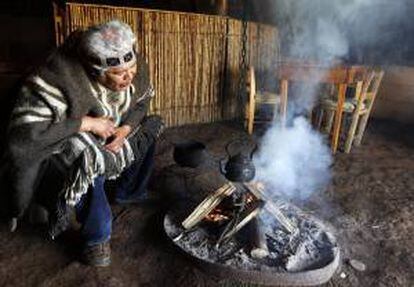 Fotografía del 7 de diciembre de 2012 que muestra al líder de la comunidad Llaguepulli, Mauricio Painefil, mientras prepara té en una cabaña tradicional a orillas del Lago Budi, en la región de la Araucanía, Chile. EFE/Archivo