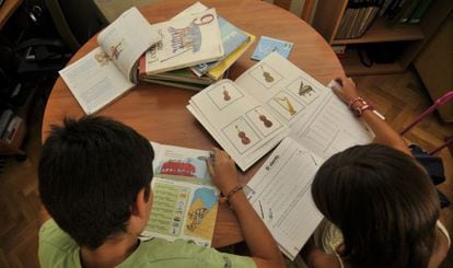 Alumnos en clase consultando sus libros de texto.