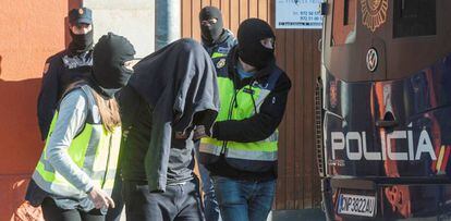 Agentes de la Polic&iacute;a Nacional acompa&ntilde;an a uno de los detenidos en Figueres. 