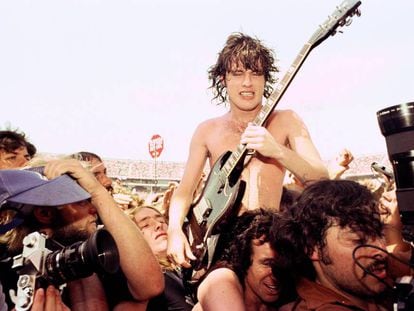 Bon Scott (se le ve media cara) pasea a hombros entre los espectadores a Angus Young. Fue en 1978 en el Coliseum de Oakland, California. / GETTY IMAGES