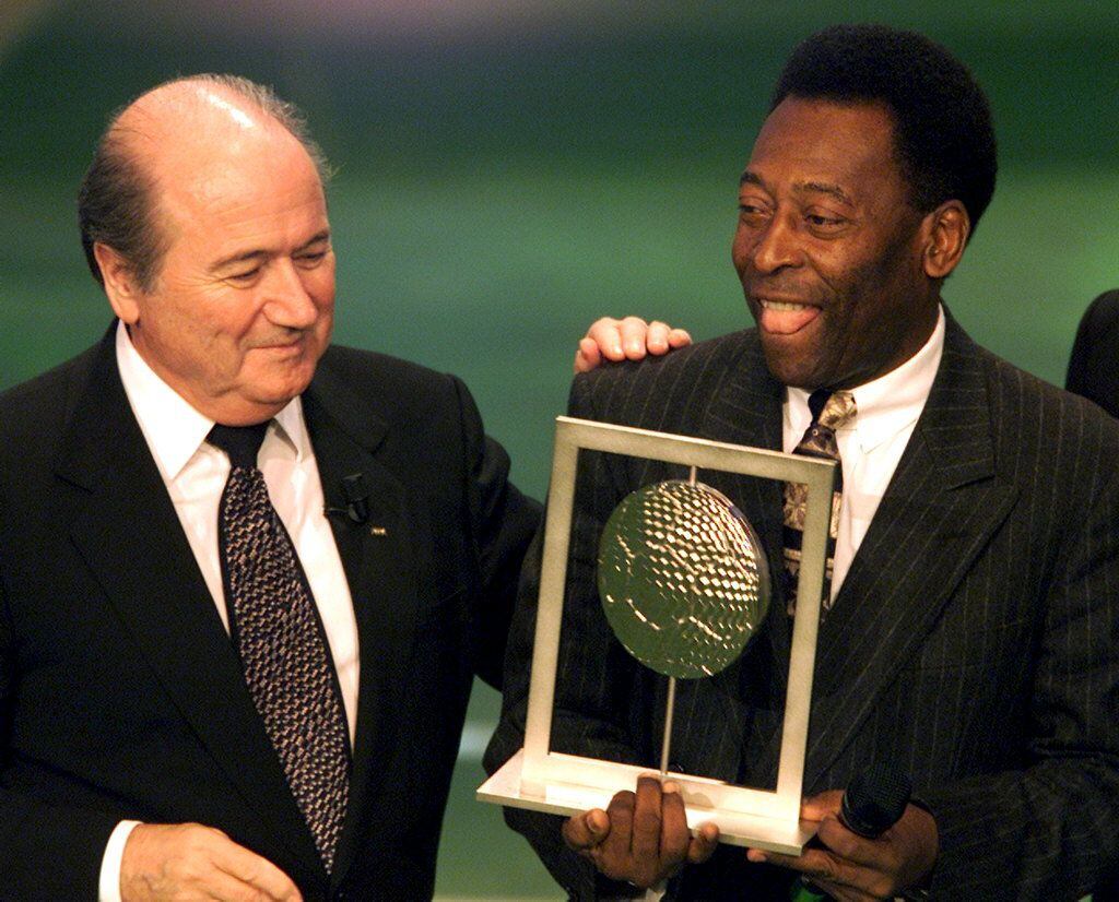 Pelé recibe el trofeo de mejor jugador del siglo de manos de Joseph Blatter, presidente de la FIFA, en Roma, en 2000.