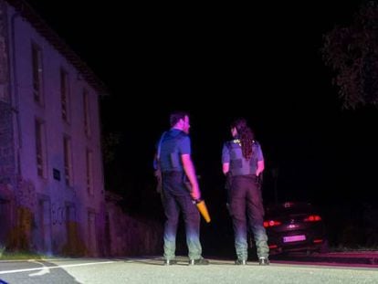 Dos agentes de la Guardia Civil cortan anoche la carretera que lleva a la casa del atrincherado en Turieno.