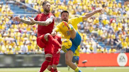 Sergio Ramos despeja el balón ante el acoso de Javi Muñoz.