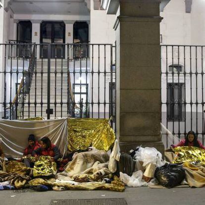 Un grupo de solicitantes de asilo se dispone a pasar la noche frente a la sede del Samur Social, en el centro de Madrid.