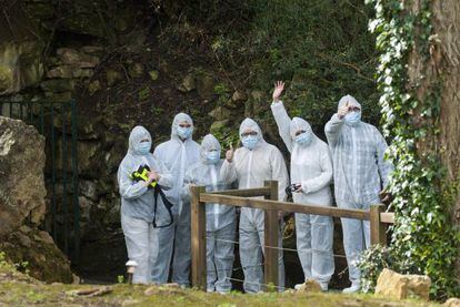 Los primeros visitantes de la Cueva de Altamira tras permanecer cerrada 12 años saludan antes de iniciar la visita.