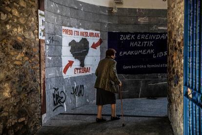 Una mujer camina junto a un cartel que reclama el acercamiento de presos de ETA, en Hernani (Gipuzkoa).