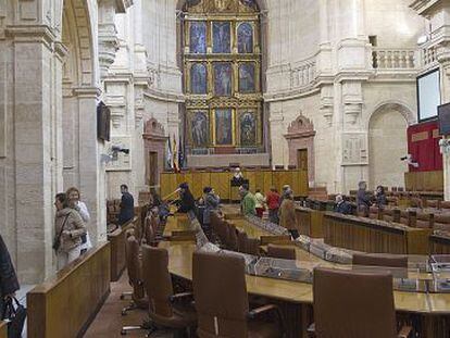 Unos visitantes se fotografían en el Salón de Plenos del Parlamento.