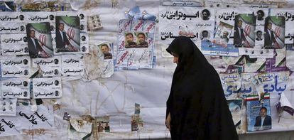 Una iraní pasa ante varios carteles electorales en Teherán este lunes.