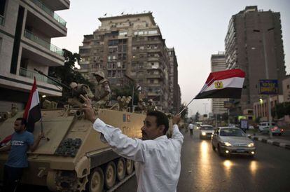 Opositores egipcios junto a los tanques militares que custodian una calle cercana a la Universidad de El Cairo, 3 de julio de 2013.