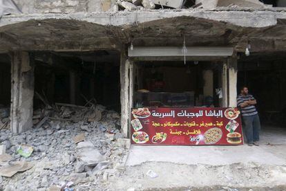 Un vendedor de comida rápida espera clientes en una calle de Alepo (Siria).