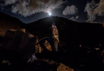 Un joven migrante bajo la luz de la luna llena acampa en una ladera de la costa deshabitada de Las Palmas tras su expulsión del campo Canarias 50 el 28 de febrero.