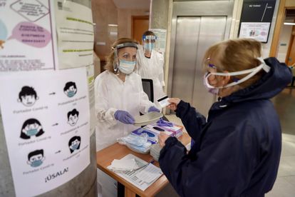 Trabajadores sanitarios del centro de salud de General Ricardos, en Madrid, atienden a una paciente