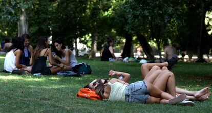 Varios adolescentes descansan en el parque del Retiro de Madrid en 2016.