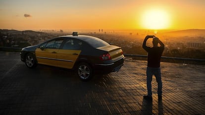 Barcelona. Un taxista de la capital catalana toma fotografías del perfil urbano desde lo alto del monte Tibidabo al amanecer.