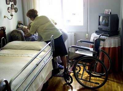 Una enferma de alzhéimer, atendida por su hija en su domicilio.