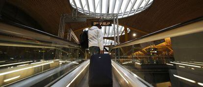 Un pasajero sube con un trolley por la rampa autom&aacute;tica de la T- 4 del aeropuerto de Madrid- Barajas. 