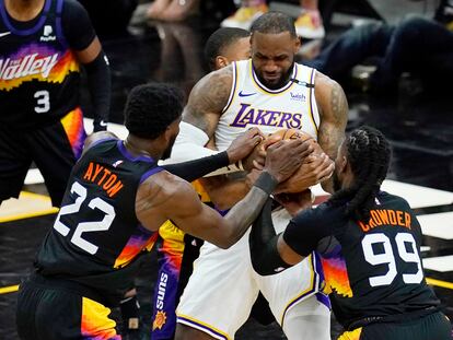 Ayton y Crowder tratan de arrebatarle la pelota a LeBron James.