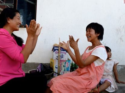Una enfermera hace palmas con una paciente con parálisis cerebral en un centro de China.