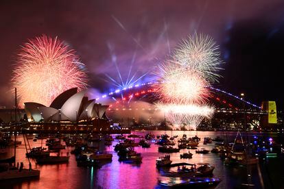 Los fuegos artificiales explotan sobre el puerto australiano de Sídney mientras comienzan las celebraciones de Año Nuevo.