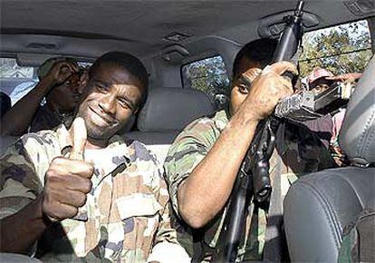 Guy Philippe (izquierda) saluda a sus simpatizantes desde un vehículo ayer en Puerto Príncipe.