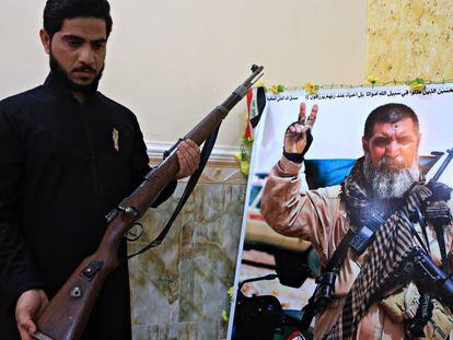 El hijo de Ali Jayad al Salhi, héroe entre los milicianos chiíes, posa en Basora junto a una foto de su padre, muerto en combate contra el ISIS.