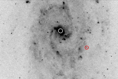 Imagen, tomada con el Hubble, de la galaxia (centro  marcado con un círculo blanco), de la que posiblemente se está escapando un agujero negro (marcado en rojo).